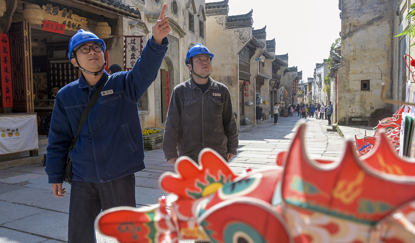 农村电气化信息网讯：（通讯员 王国红 摄）2月12日，国网婺源县供电公司紫阳供电所电力工人在弦高西湖凼古城进行巡视，检查古城的商户线路和用电安全。