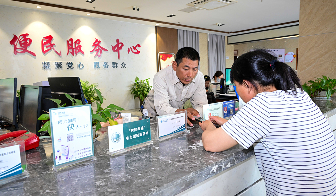 6月16日，江苏省淮安市金湖县塔集镇金桥村村网共建点，电暖流党员服务队员李暑荣为村民下载网上国网APP，并开展节能用电知识宣传。